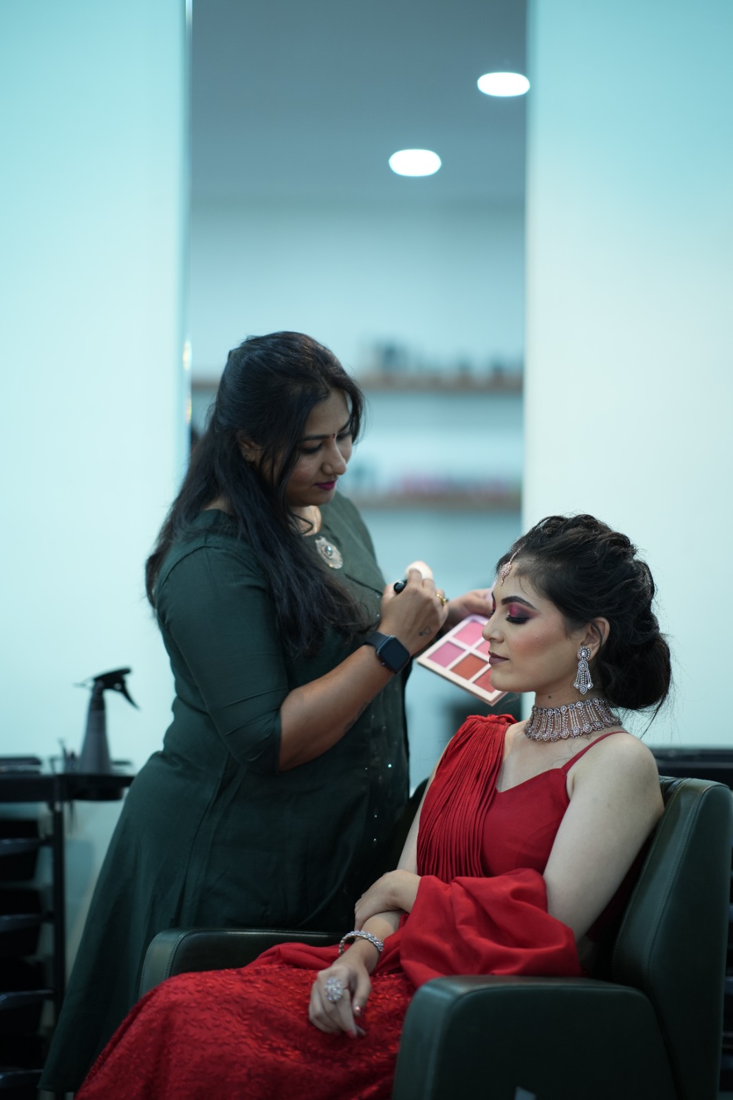 Ranjitha applying eyeshadow to client